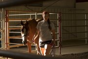 Andrea Steward, 16, of Lawrence, leads her horse around the arena Saturday in the Community Building at the Douglas County Fairgrounds. Andrea said she was getting the horse used to the arena before the show began.