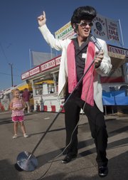 Wade Morrow, who will be participating in the first Elvis Spectacular on Saturday in downtown Lawrence, was at the Douglas County Fair Thursday in full Elvis mode to promote the event. Morrow is also a square-dance caller and was at the fair for a performance with the Happy Time Squares square-dance organization.