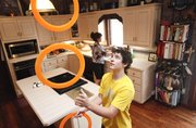 Noah Schmeissner, a 15-year-old juggler, practices his talent with a set of rings as his mother Baretta Schmeissner works in the kitchen of their Valley Falls home on Wednesday, Aug. 1, 2012. Schmeissner, who competes in national juggling competitions yet has only been actively juggling for two years, says that he practices sometimes up to three hours a day in their kitchen.