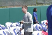 Charlie Weis Jr. walks through players stretching prior to Monday's practice at the KU practice fields.