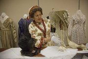 Marge Harding, from Oregon City, Ore., sets up a display of period dress for the 1840s as part of the Oregon and California Trails Association meeting on Wednesday at the Lawrence Holidome. More than 300 people have come for the convention.