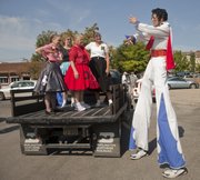 Richard Renner, right, strikes a pose for members of the Happy Time Squares square-dance organization before the first Downtown Lawrence Elvis Spectacular kicks off with a parade Saturday. The parade was followed with an Elvis Sing-Off competition and the annual Rev It Up car show in South Park.