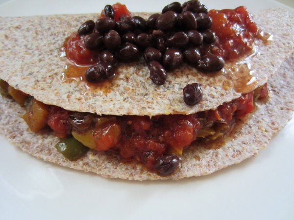 Fajita veggies with black beans, chopped mango and peach salsa on a sprouted tortilla.