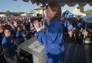 Kansas women's basketball head coach Bonnie Henrickson pumps up the crowd Friday during the KickOff at Coringth Square in Prairie Village for the Kansas football season.