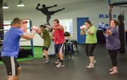At left boxing instructor John Heleniak, leads a group through a class at Punch Boxing and Fitness, 4931 W. 6th St. Participating in the class from left are Heleniak, Mike McAtee, Craig Eddis, Caitlin Brown and Ali Cook.