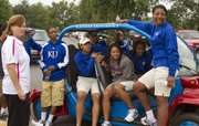 Kansas women's basketball coach Bonnie Henrickson, left, hangs out with members of her team around a Jayhawk-themed golf cart before the start of the eighth annual Bonnie Henrickson Golf Tournament on Saturday, August 25, 2012, at Alavamar.