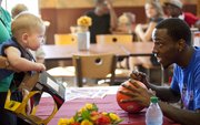 Tyshawn Taylor locks eyes with 8-month-old Finnegan Nicholas, Lawrence, as Finnegan and his mother, Karen Nicholas, wait for the former Kansas guard's autograph, Monday, Aug. 27, 2012 at the recently reopened Dillon's on Massachusetts Street. Taylor, who was acquired by the Nets with the 41st pick in the 2012 NBA Draft, spent part of the afternoon and evening signing autographs at the store.