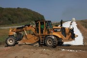 Work crews lay a lime slurry mixture on U.S. Highway 59 near County Road 458 on Tuesday morning. The slurry helps harden the surface for the asphalt-laying stage.