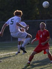 Free State junior Alex Trent (5) uses his head to slip the ball past Bonner Springs' Austin Schuler (4) and into the goal for a score during their soccer match Thursday, August 30, 2012, at FSHS.