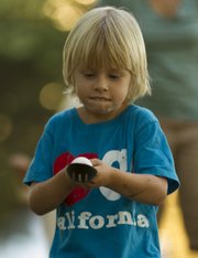 Henry Gottsfield, 5, of Lawrence, concentrates on keeping his spoon steady as he takes part in an egg-and-spoon race during the picnic Saturday.