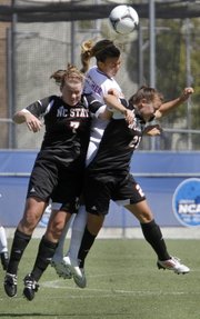 Jamie Fletcher, center, heads the ball between defenders in the Jayhawks' soccer match against North Carolina State on Saturday, Sept. 9, 2012, at the Jayhawk Soccer Complex.