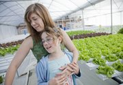 Caroline Eddinger and her daughter Stella, 10, help operate Two Sisters Farm where a hydroponic greenhouse system is used to grow several varieties of lettuce. They sell "living lettuce" to several Lawrence area grocers and restaurants.