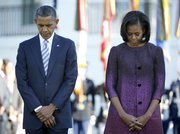 President Barack Obama and first lady Michelle Obama, joined by members of the White House staff pause during a moment of silence to mark the 11th anniversary of the Sept, 11th, Tuesday, Sept. 11, 2012, on the South Lawn of the White House in Washington.