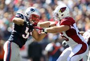 Former New England Patriots linebacker Mike Rivera, left, fights through a block by Arizona Cardinals running back Anthony Sherman during their game on Sept. 16, 2012, in Foxborough, Mass.