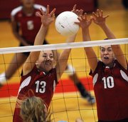 Lawrence High's Caroline Dykes, left, Monica Howard team up for a block against Shawnee Mission East on Thursday, Oct. 4, 2012, at LHS.