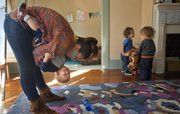 Ashleigh Ward, assistant director of OmSprout Creative Play and Drop-in Care, 1341 Mass. Apt. 1, dips Liam Kearn as Memphis Branum, right, and Zephyr Manriquez Gardner play in the main area of the child care center. The center is designed to cater to parents who prefer a holistic environment and need a flexible day care schedule.