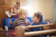 Townes Windhol, left, and Zephyr Manriquez Gardner share a glance as the two rock together in a wooden teeter totter on Wednesday at OmSprout. The child care center is designed to cater to parents who prefer a holistic environment and need a flexible day care schedule.