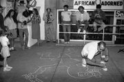 Artist and social activist Keith Haring draws on the sidewalk of Seventh Street in downtown Lawrence during the River City Reunion, which took place Sept. 7-13, 1987. The event brought together beat generation writers, punk bands and social activists.