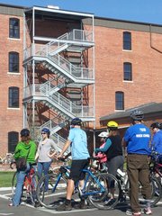 Abby Pierron, second from left, shows a group on a bike tour the Poehler Loft Apartments at 619 E. 8th. The apartments were built from a former grocery warehouse, one example of East Lawrence's industrial past.