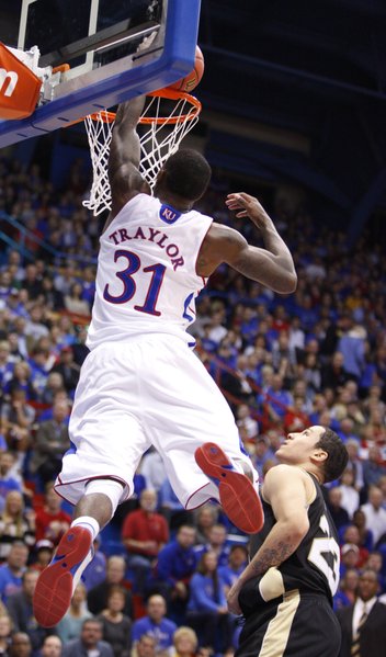 Kansas forward Jamari Traylor delivers a jam over Emporia State guard Tre Boutilier during the first half, Tuesday, Oct. 30, 2012 at Allen Fieldhouse.