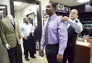 Troy Baptiste is fitted for a suit by tailors Mohan Ramchandani, right, and Bobby Kumar, left, at Mohan’s Custom Tailors, Jan. 31 in New York. Having a tailor mend or fit clothes can save money over buying new ones.