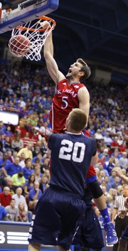 Kansas center Jeff Withey dunks as Washburn forward Bobby Chipman watches during the second half on Monday, Nov. 5, 2012 at Allen Fieldhouse.