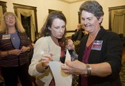 Jami Jones, wife of John Wilson, candidate for State Representative 10th District, and Douglas County Commissioner Nancy Thellman look over vote counts at the Douglas County Courthouse on Tuesday evening. Thellman was running against Republican Frank Male, and Wilson was running against Republican Erica Anderson. Jones is holding her 3-month-old son, Parker.