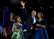 President Barack Obama waves as he walks on stage with first lady Michelle Obama and daughters Malia and Sasha at his election night party Wednesday, Nov. 7, 2012, in Chicago. Obama defeated Republican challenger former Massachusetts Gov. Mitt Romney.