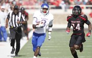 Kansas running back Tony Pierson heads up the sideline as Texas Tech defensive back Bruce Jones trails during the second quarter on Saturday, Nov. 10, 2012 at Jones AT&T Stadium in Lubbock, Texas.