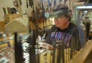 Bill Collins, of Lawrence, a jeweler and silversmith, works on some of his unique Kansas pendants Wednesday in his home studio. Collins will have pendants, pins, earrings and other jewelry for sale from 10 a.m. to 5 p.m. Sunday at the 36th annual Holiday Bazaar at the Community Building, 115 W. 11th St.