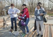 Xueying Wang, center, holding her daughter, Serenity, 7, thanks gathered Habitat for Humanity supporters and friends for help in starting her future home during a nail-drive ceremony Saturday in North Lawrence. Wang’s home will be the 81st by Lawrence Habitat for Humanity. At left is Erika Zimmerman, Habitat family partner, and at right is Wang’s son, Jake, 20, and her mother, Ling.