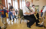 John Bechen instructs a group of preschoolers on how to shake their bells before a performance of “Pennsylvania 6-5000” Nov. 30 for preschoolers at Kids First Preschool, 867 Highway 40. The saxophone quartet made of longtime musicians perform throughout the community.