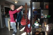 Debra Rukes, owner of Kretyen, 2116 W. 25th street, hangs some Guatemalan purses in her quaint store full of fair trade items.