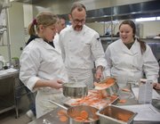 From left, Bailey Campbell, a Eudora sophomore in her first year in culinary arts at the Eudora-De Soto Technical Education Center at Eudora High School, her instructor Rick Martin and sophomore Madison McGinness prepare sweet potato gratin Saturday at Eudora High School. Students in the culinary arts program, along with help from friends and parents, were preparing six gourmet meals for families in need as part of an Adopt-A-Family program.
