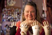 Jerry Dowdle of Lawrence is pictured with fingerless gloves and accessories she has upcycled from used or damaged sweaters. Dowdle calls her business TerranJerran: Taming the Tattered and sells on Etsy and at arts and crafts fairs.