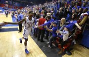 Kansas fans reach to slap hands with Ben McLemore as he exits the floor after a 33-point performance and a game-tying three that send the game into overtime on Wednesday, Jan. 9, 2013 at Allen Fieldhouse.