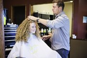 Ryan Crowell, right, styles the hair of Coleen Nelson at Salon Lucca, 3727 W. Sixth St. Nelson says she used to chemically relax and straighten her her, but she now wears it curly to avoid damaging it. “It makes me feel a lot more of who I am because it was what I was born with and what I have every day,” Nelson says.