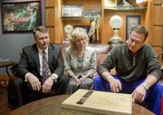 Kansas basketball coach Bill Self signs a piece of the floor from the New Orleans Superdome court used during the 2012 NCAA championship game between KU and Kentucky. Joe and Nancy Jones of Lawrence, left, acquired 50 pieces of the Final Four floor, some of which were then signed by Self on Jan. 23 and will be auctioned off for charity.