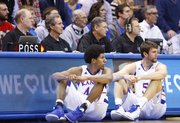 Scoreboard operator Robbie Vannaman, far left, keeps watch of the game as Kansas players Kevin Young and Jeff Withey look to check in during the first half of the Jayhawks' game against American University on Saturday, Dec. 29, 2012, at Allen Fieldhouse.
