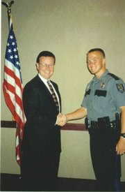 Christopher Mann, as a young police officer with the Lawrence police, shaking hands with former Lawrence Police Chief Ron Olin, left.