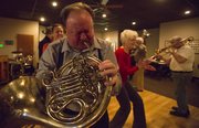 Paul Jolley, Osawatomie, plays "When the Saints Go Marching In" on his French horn while circling the dance floor with other members of the Junkyard Jazz band on Thursday, Feb. 14, 2013, at the American Legion.