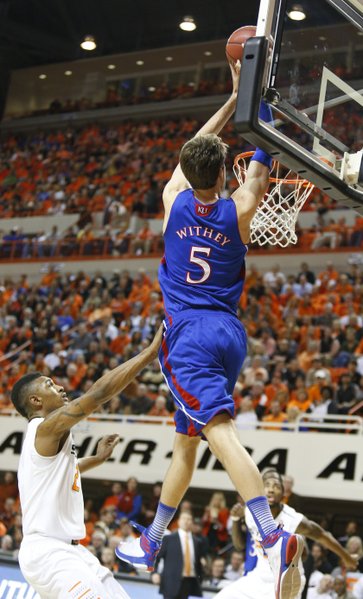 Kansas center Jeff Withey comes in for an alley-opp dunk over Oklahoma State forward Le'Bryan Nash during the first half on Wednesday, Feb. 20, 2013 at Gallagher-Iba Arena in Stillwater, Oklahoma.
