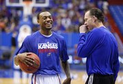 Kansas guard Naadir Tharpe laughs with assistant Joe Dooley prior to tipoff against West Virginia on Saturday, March 2, 2013 at Allen Fieldhouse.