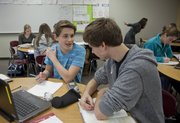 Free State high school sophomores Florian Eichblatt, left, and Zach Batterman work through some precalculus problems using both textbooks and online materials. The blending of online materials and classroom management with traditional teacher-led classroom instruction is a new model for learning that is being tested in several schools in the Lawrence district.