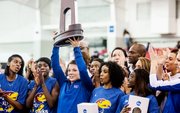 Surrounded by her Kansas University teammates, senior Andrea Geubelle hoists the second-place team trophy at the NCAA Indoor Track and Field Championships on Saturday, March 9, 2013, in Fayetteville, Ark. Geubelle won the long-jump and triple-jump individual titles, and KU placed second for the second-straight season.