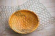 Use a bowl to help shape the chicken wire base for the nest. Soften twigs in water to make them pliable.