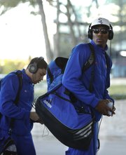Kansas players Jamari Traylor, right, and Niko Roberts exit the team bus as they arrive at the Hyatt Regency Dallas on Wednesday, March 27, 2013.