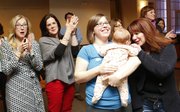 Smiles and applause fill the room as school bond issue supporters celebrate their victory shortly after the results were shown on the big screen of the Alton Ballroom at Pachamama's. Pictured from left are Nancy Hamilton, Adina Morse, Vanessa Sanburn with her three-month-old daughter, Amelia Lowen and Jennifer Osborn. Sanburn and Morse were the top two vote getters in the school board race, respectively. Nick Krug/Journal-World Photo