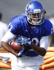 Kansas receiver Christian Matthews breaks through the gauntlet during a spring practice on Tuesday, April 2, 2013, at Memorial Stadium.