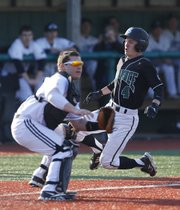 Free State runner Joel Spain slides in to tie the game behind Olathe Northwest catcher Luke Knight in the third inning on Thursday, April 4, 2013, at Free State High School.